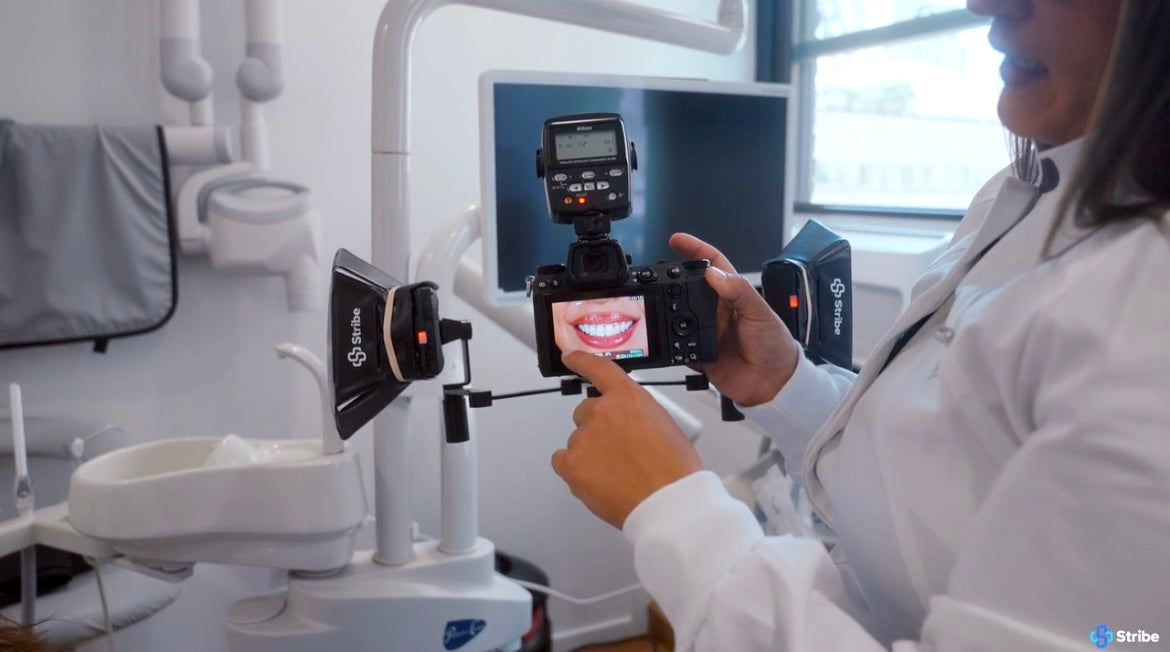 Dentist reviewing an intraoral photo on a camera fitted with Stribe Bouncers