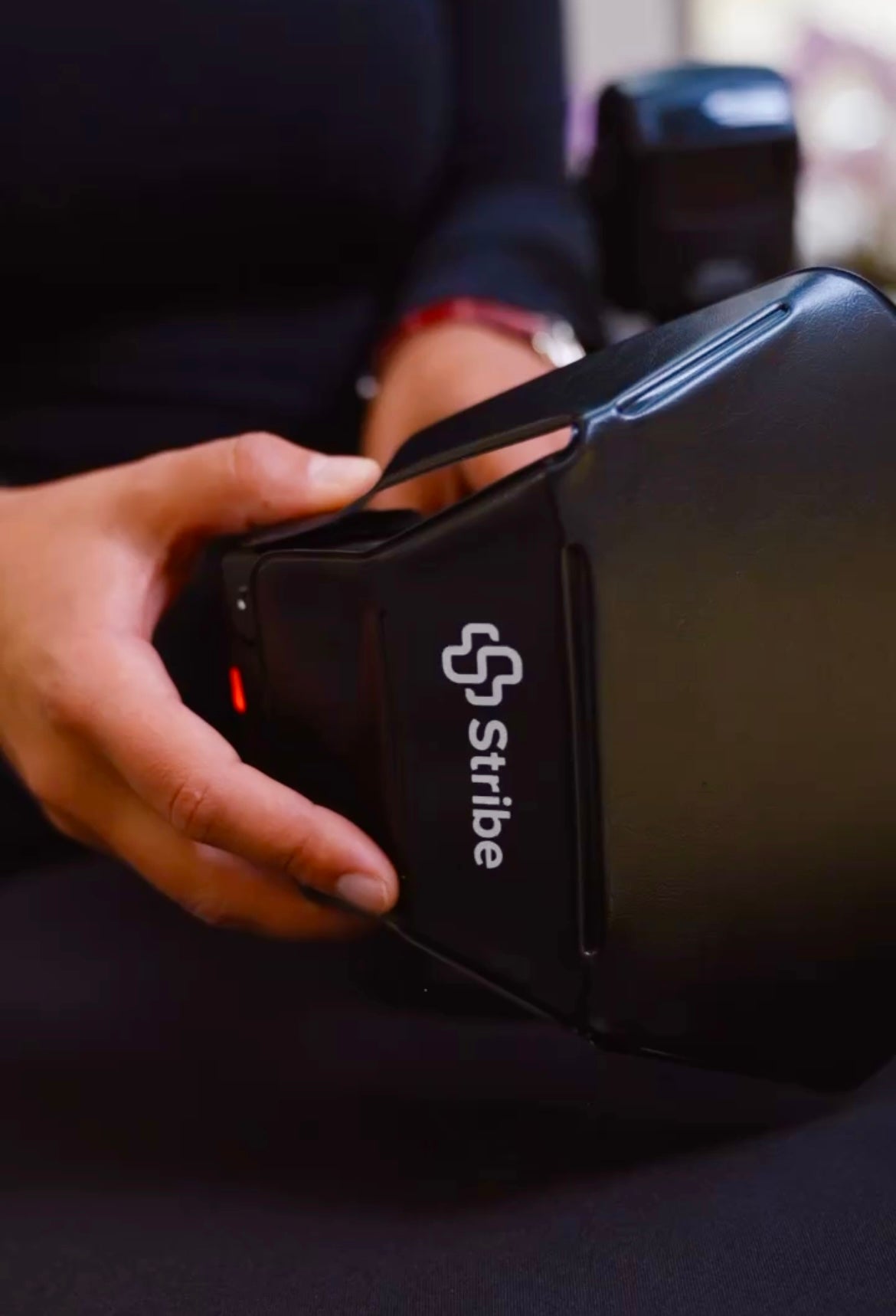 Hand fitting a Stribe Bouncer light modifier onto a camera flash