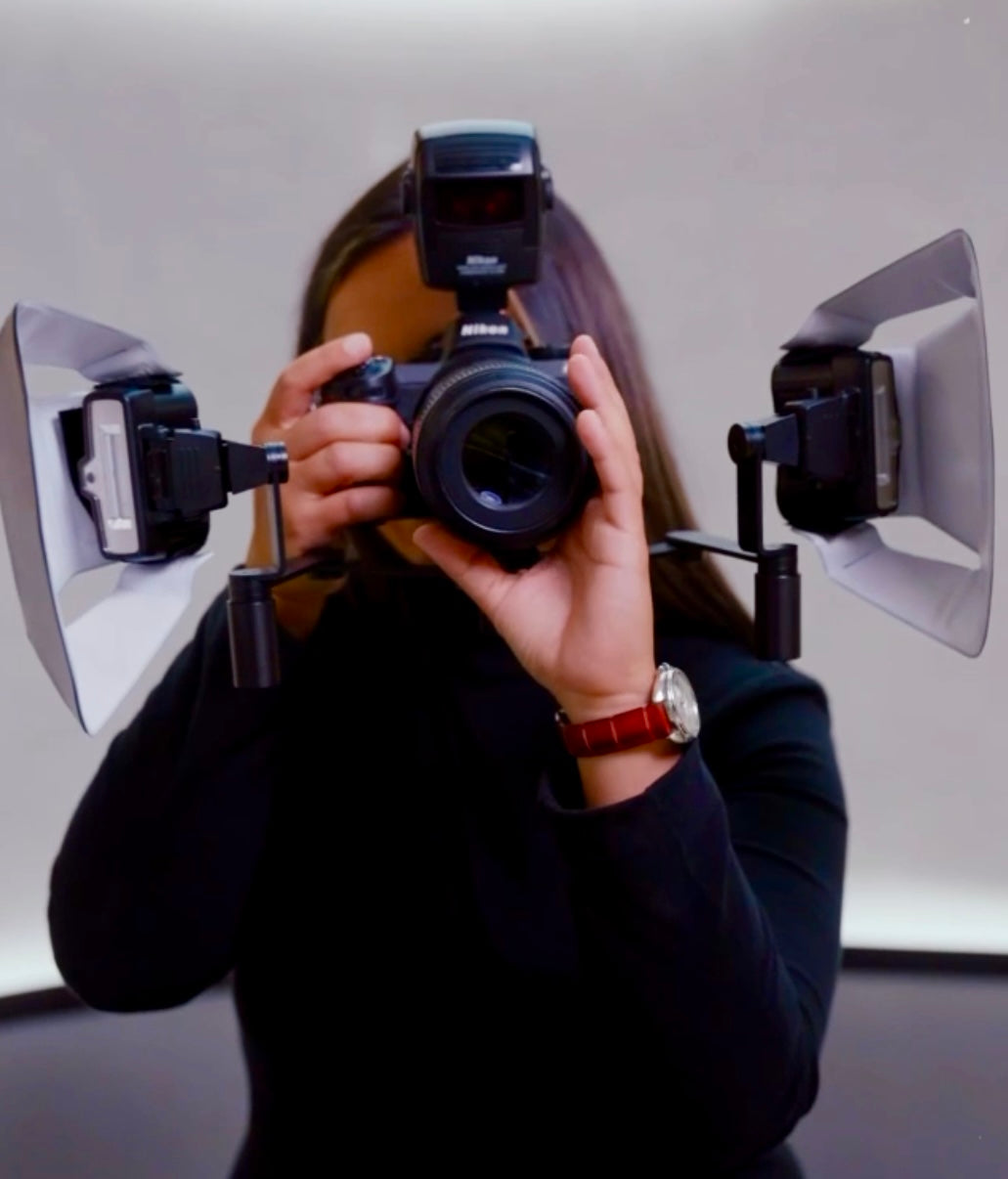 Dentist holding a camera fitted with Stribe Bouncers on twin flashes