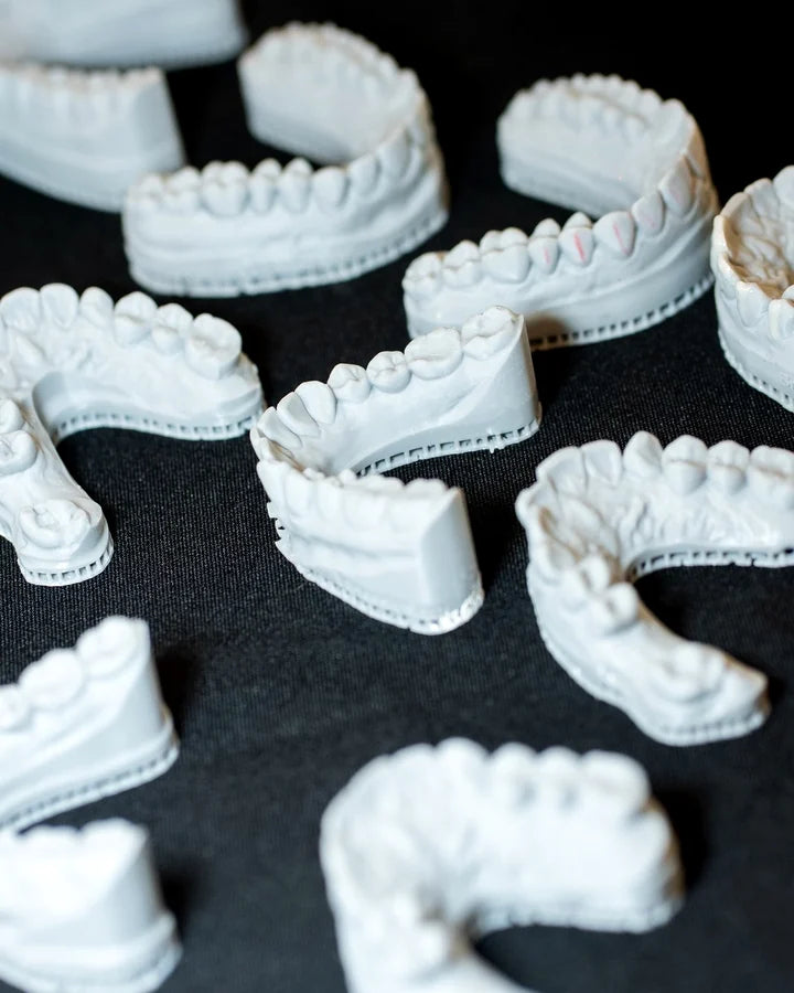 Stone dental models and sectioned arches laid out on black cloth